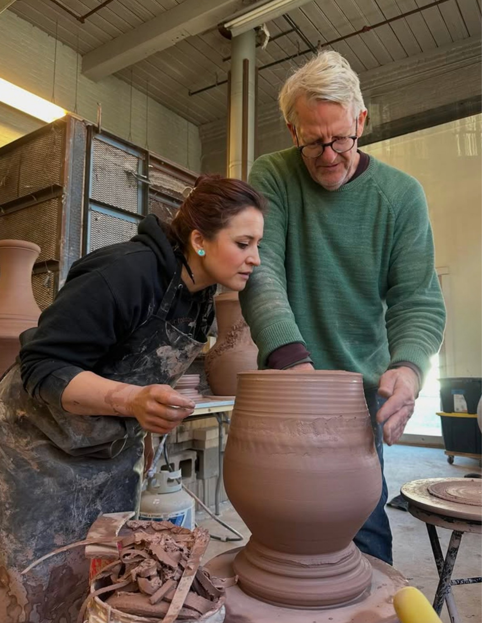 An image of Stephen Procter with a workshop participant demonstrating how to make a vessel