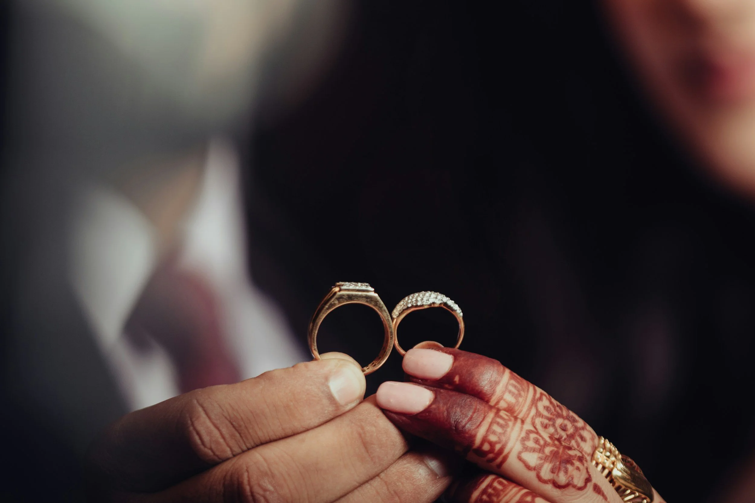 indian couple holding wedding rings
