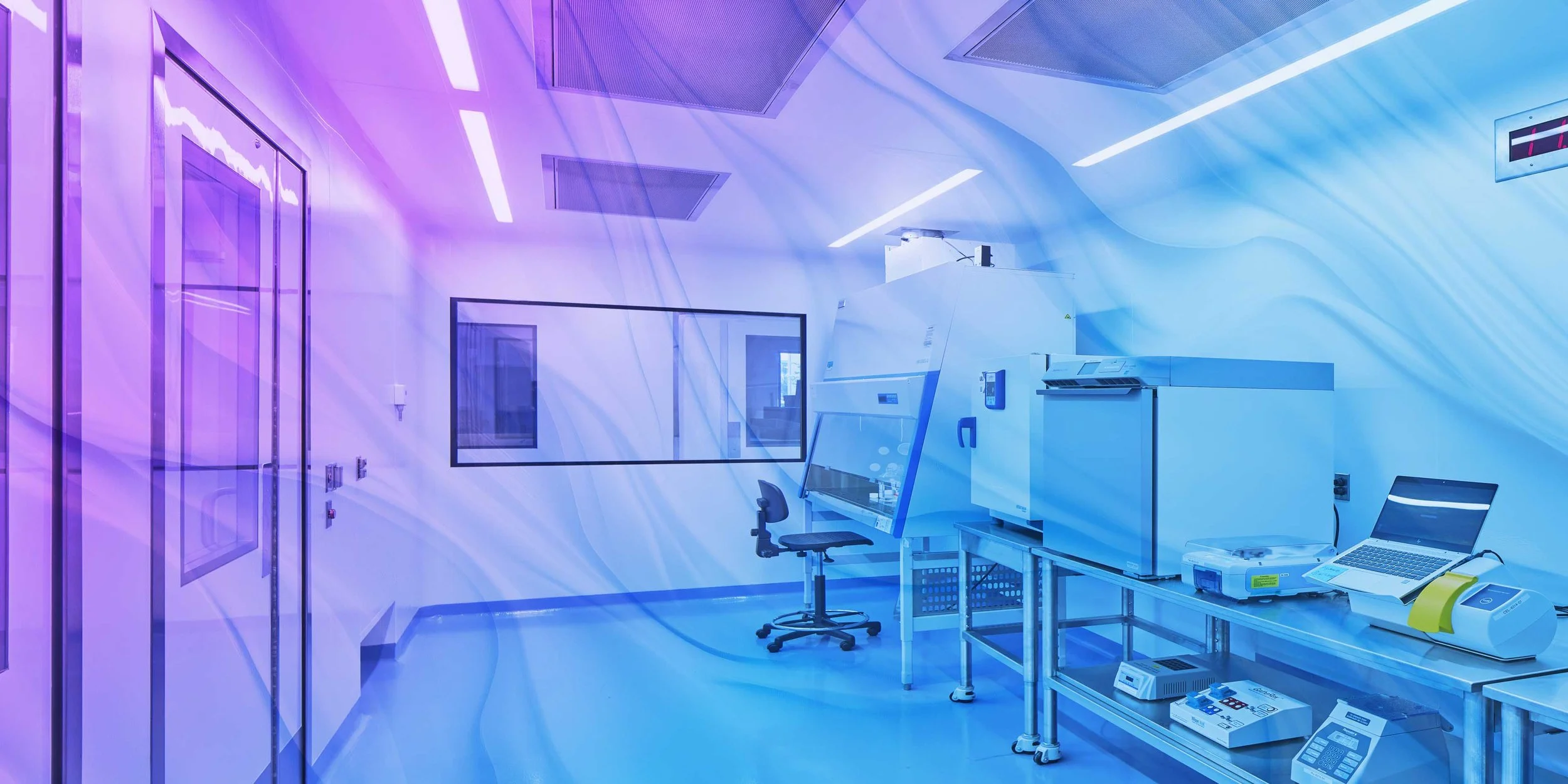 Modern laboratory with scientific equipment, chairs, tables, and a large window, illuminated by colorful lighting.