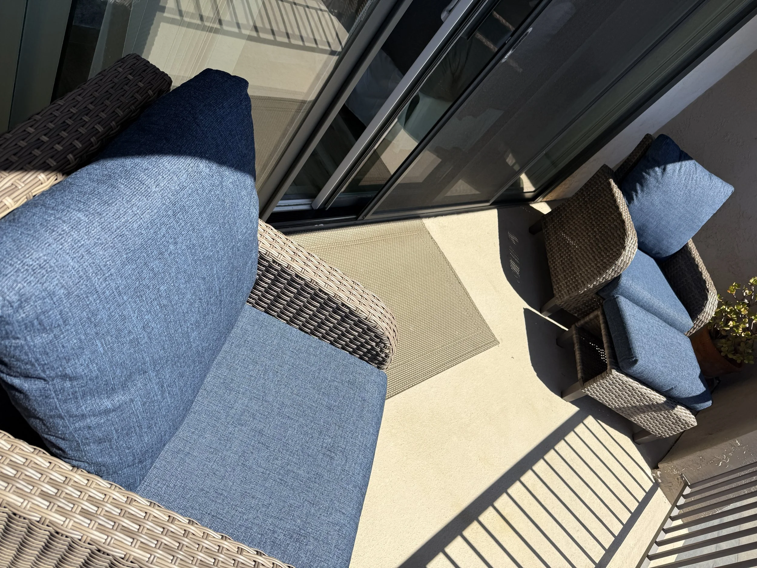 A sun-drenched balcony off of the Queens Suite in our Solana Beach vacation rental with cozy seating and a view of that endless California sky.