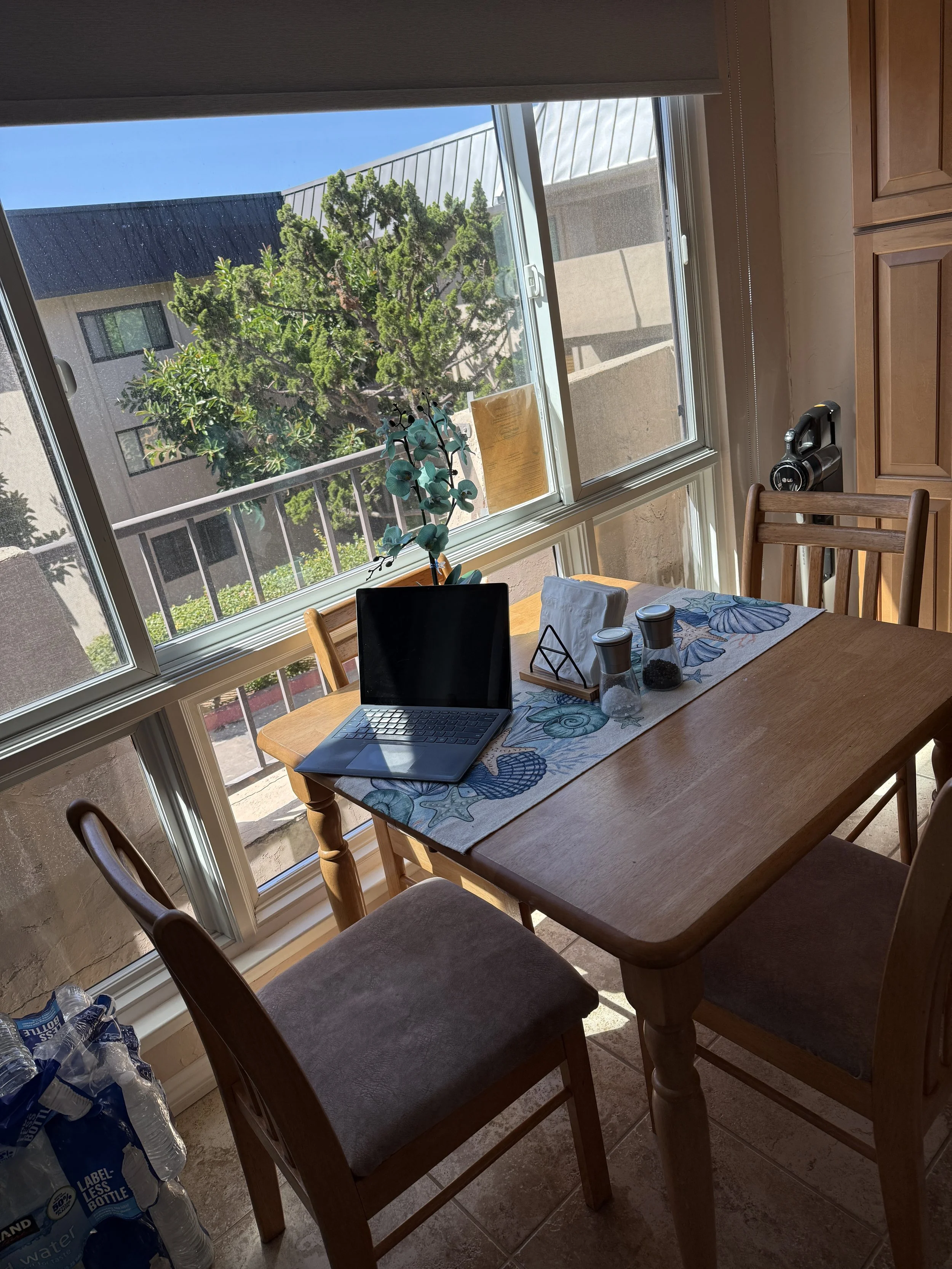 Working from the sun-drenched, eat-in kitchen table overlooking the Del Mar Beach Club where our Solana Beach vacation rental is located.