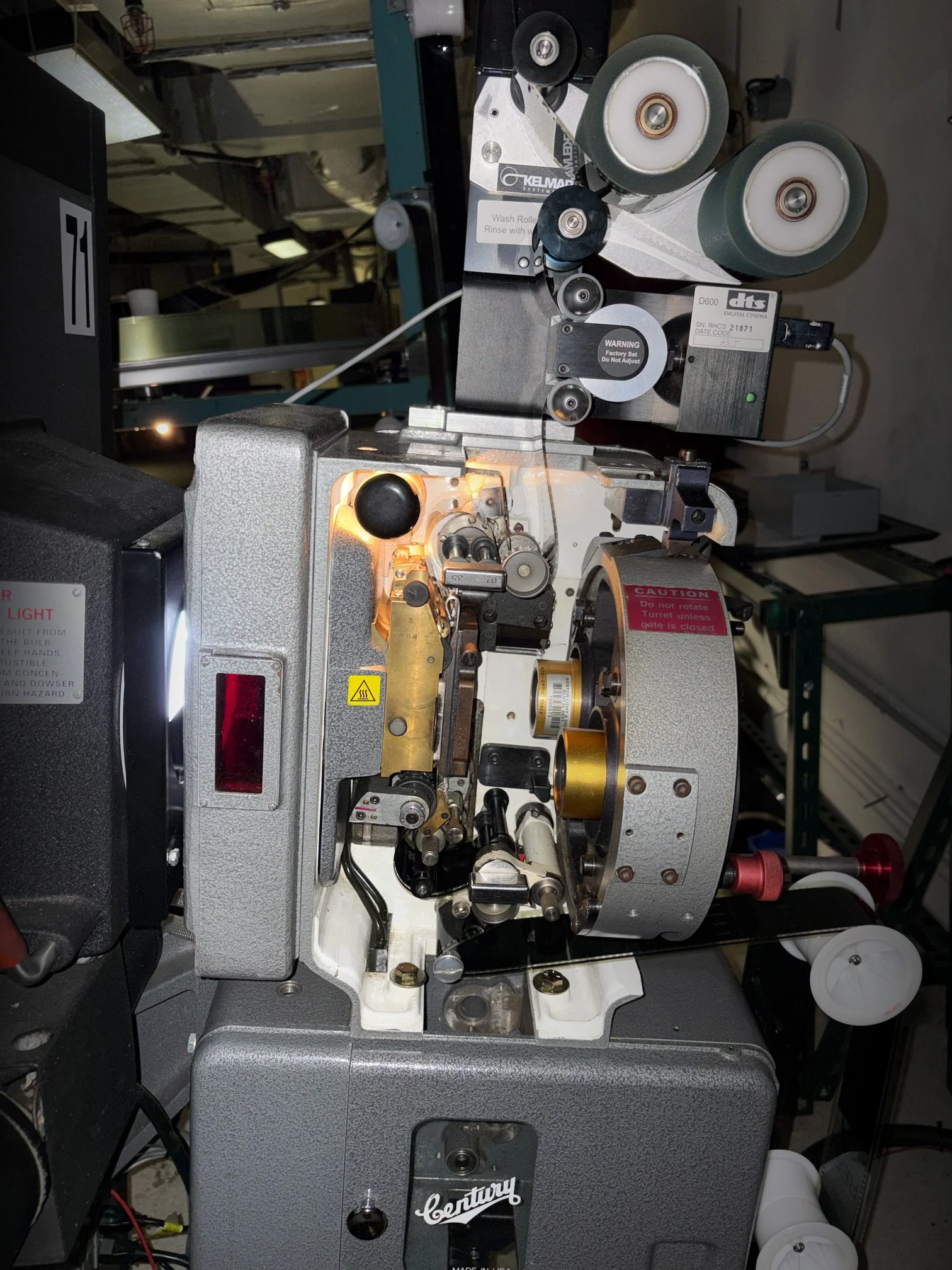   A detailed view captures the complex web of sprockets and rollers that feed the wide-gauge film.  