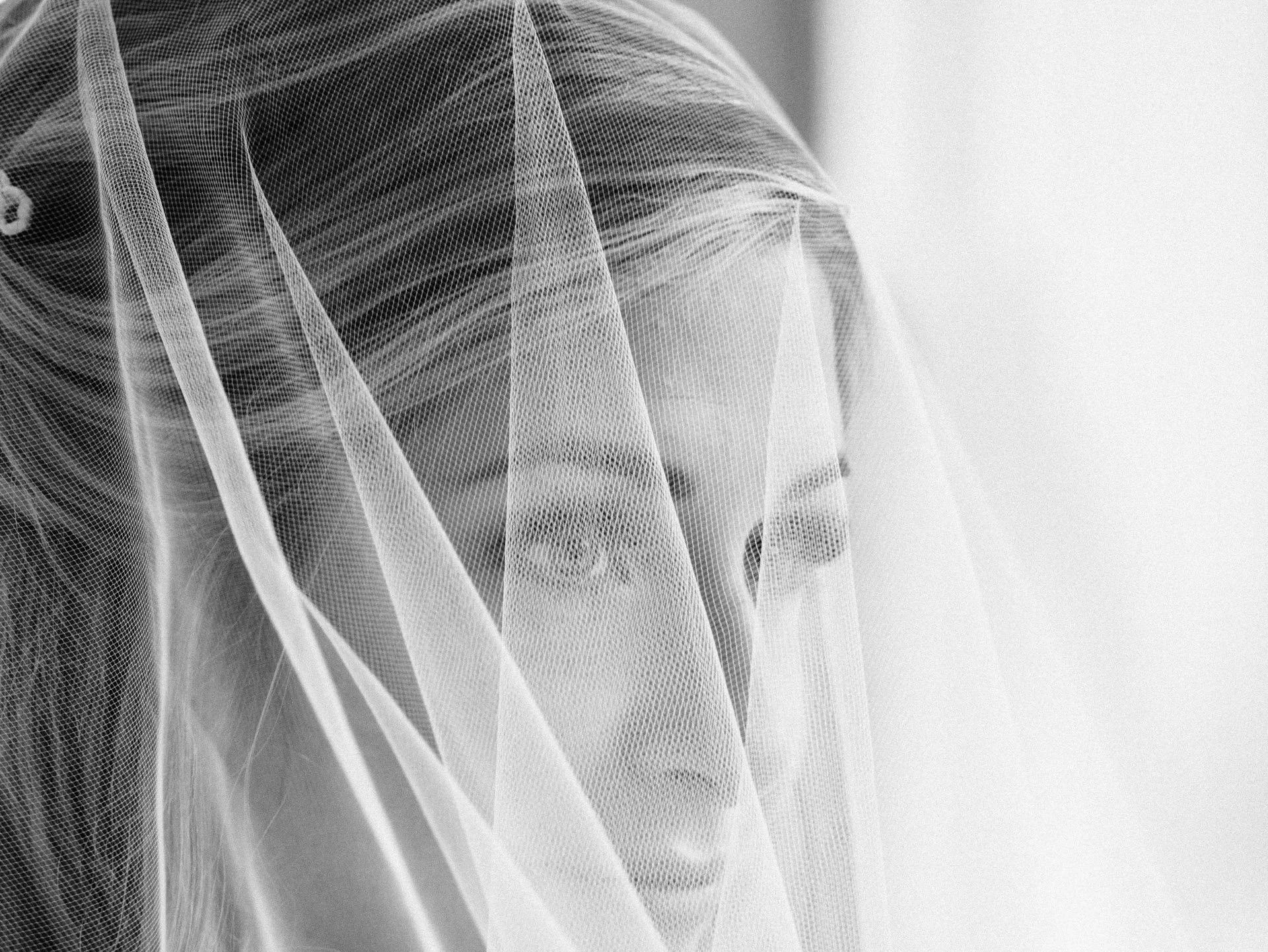 Black and white close-up photo of a woman with a veil covering her face.