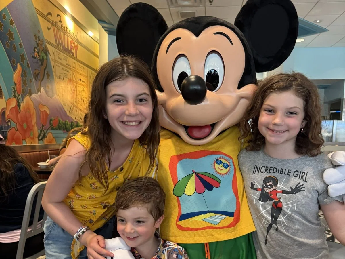 3 siblings pose with a beach-themed Mickey at Hollywood and Vine at Hollywood Studios at Disney World. It's a great buffet for kids with lots of character interactions.