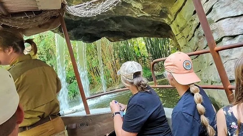 A view of the classic Disneyland California ride Jungle Cruise. The skipper is showing the classic backside of water area underneath a waterfall.