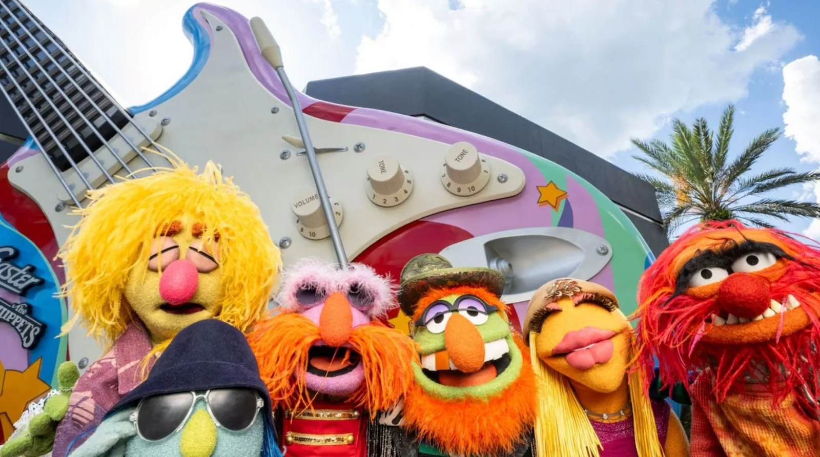 rock n roller coaster photo with muppets standing in front of the multicolored fender stratocastor.
