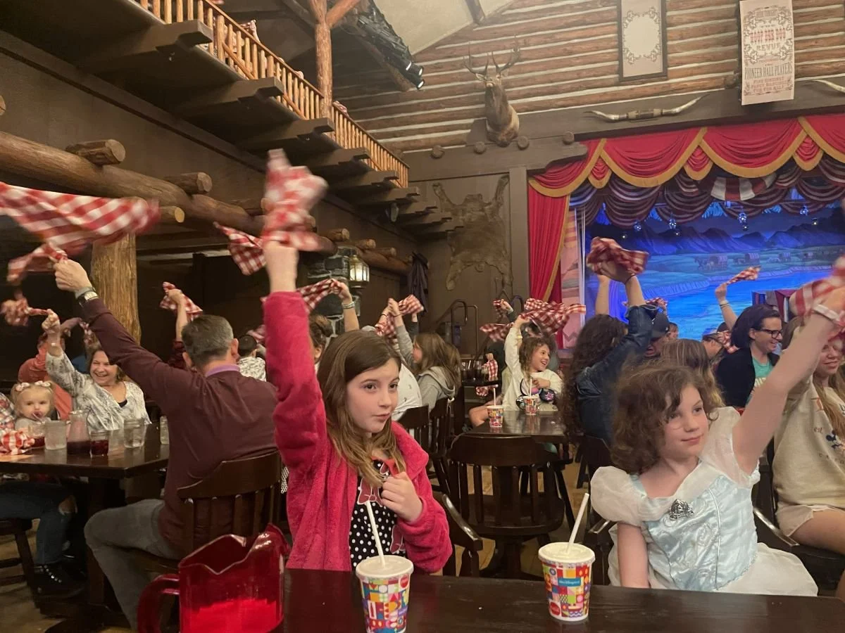 Audience members swinging napkins around their heads at Hoop Dee Doo Musical Revue in Fort Wilderness, Disney World. A fun restaurant for families.