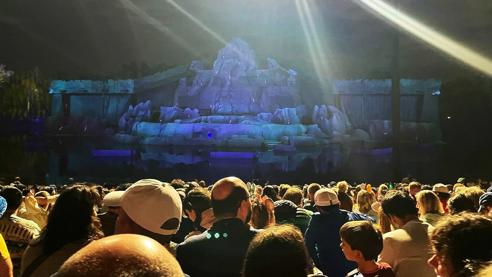 An image of the stage of fantasmic in the ampitheater at Hollywood Studios. It's a giant mountain structure surrounded by a moat.