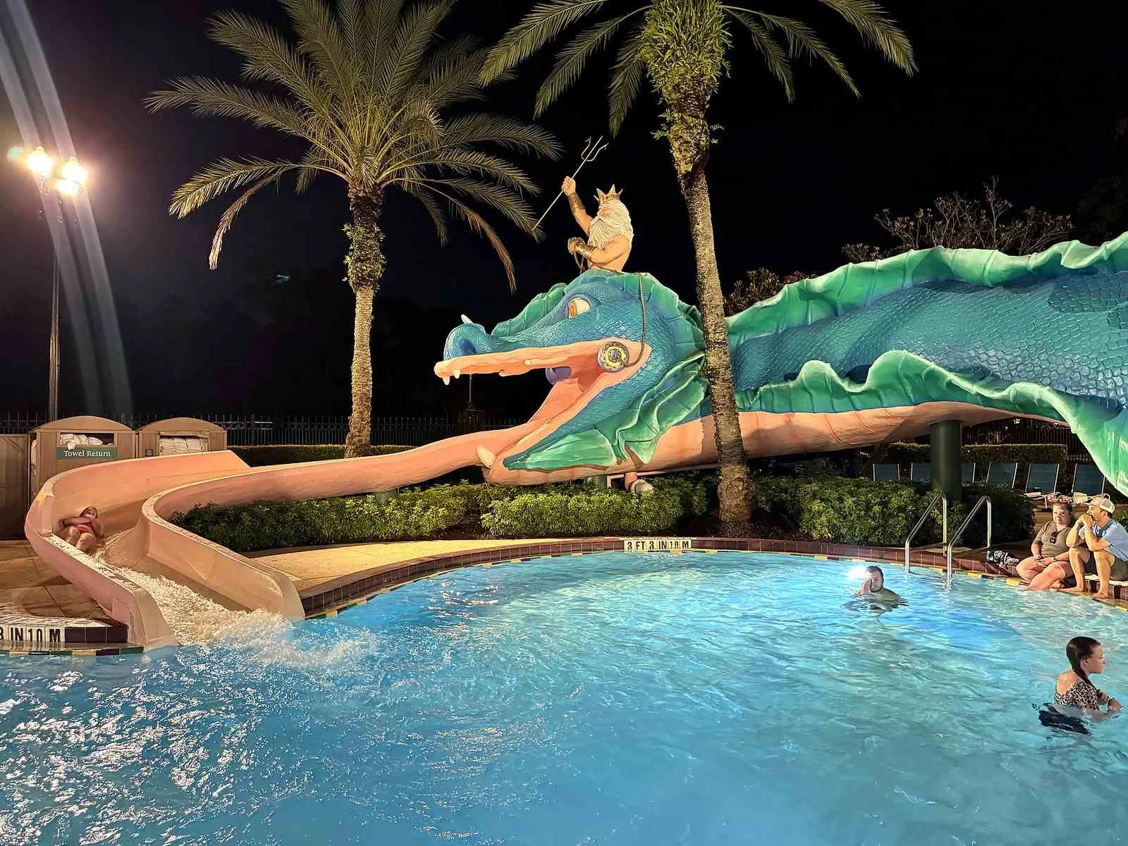 A picture of Disney's French Quarter slide, Scales. Poseidon rides the head of giant blue/green sea monster, and the tongue is the slide.
