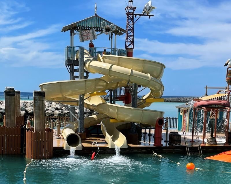 The front of pelican plunge at castaway cay, Disney's private island, with two intertwined water slides and a splash pad off to the right.