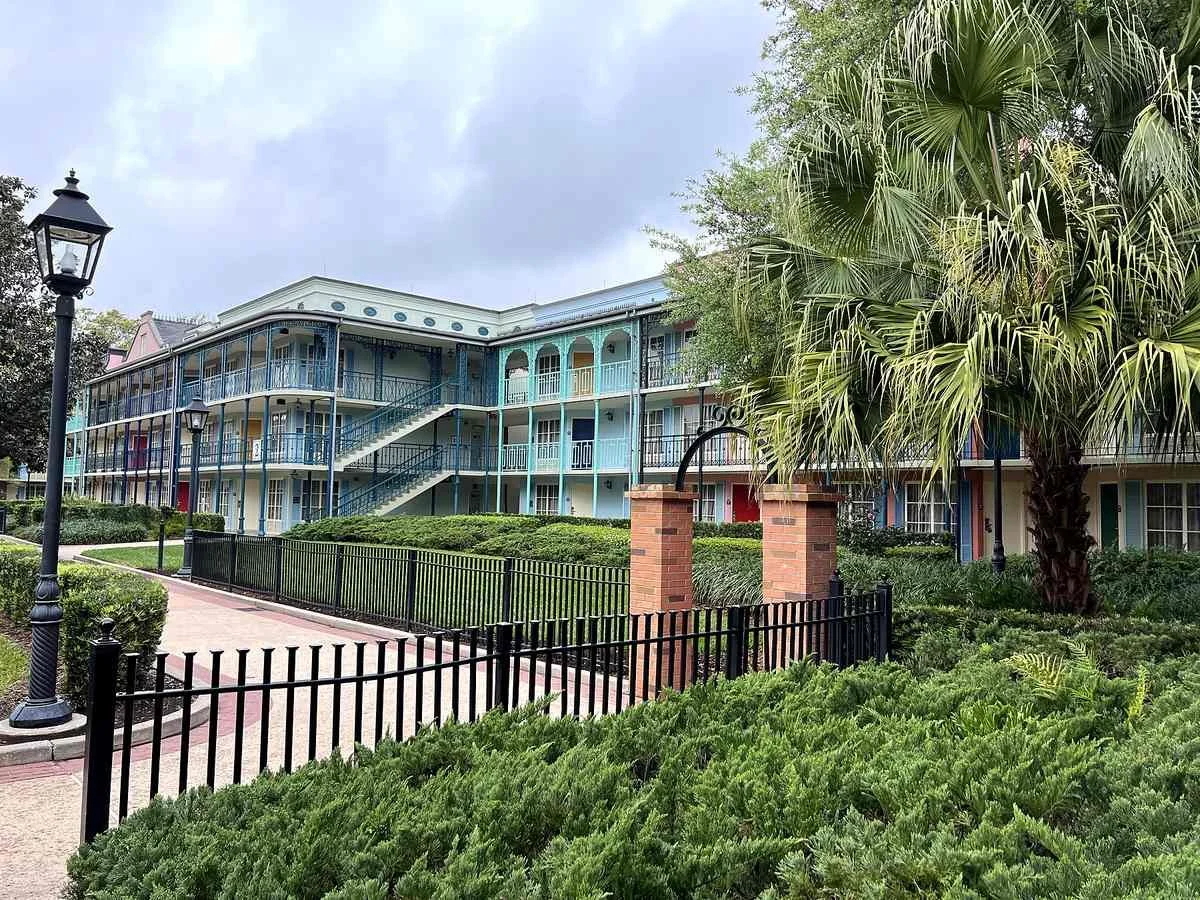 Rooms and Walkways at Disney's Port Orleans French Quarter. Lots of manicured boxwoods, brick, wrought iron, and bright colors alternating every two rooms. Very New Orleans.