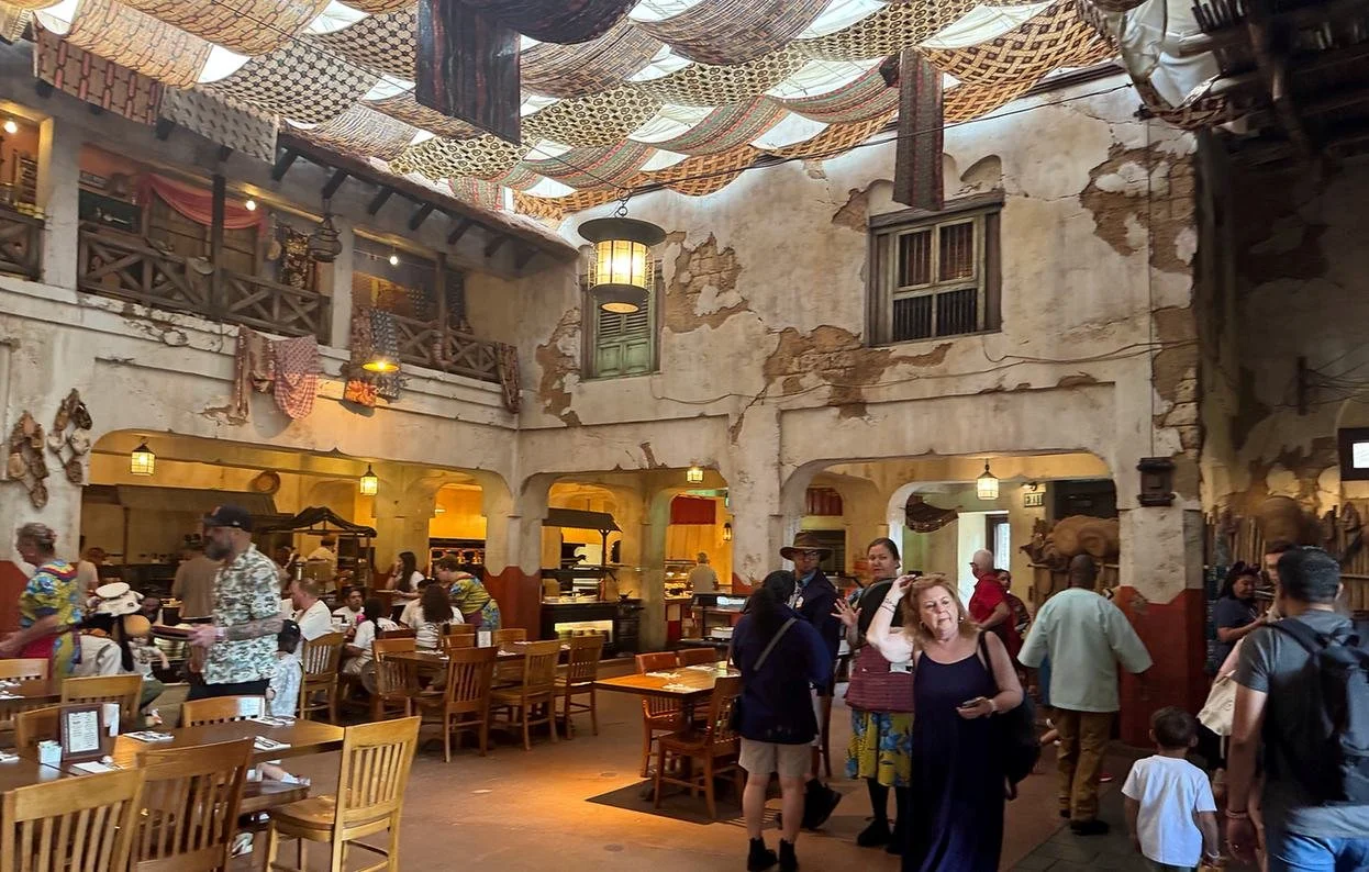 The African market theming at Tusker House, a character meal at Disney World. You can see distressed plaster walls, tapestry roofing, and other authentic touches.