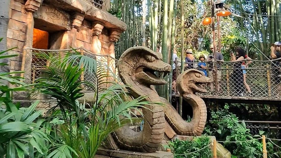 The entrance to the Indiana Jones ride in Disneyland. It has two large Cobra statues in front of an Aztec temple door.