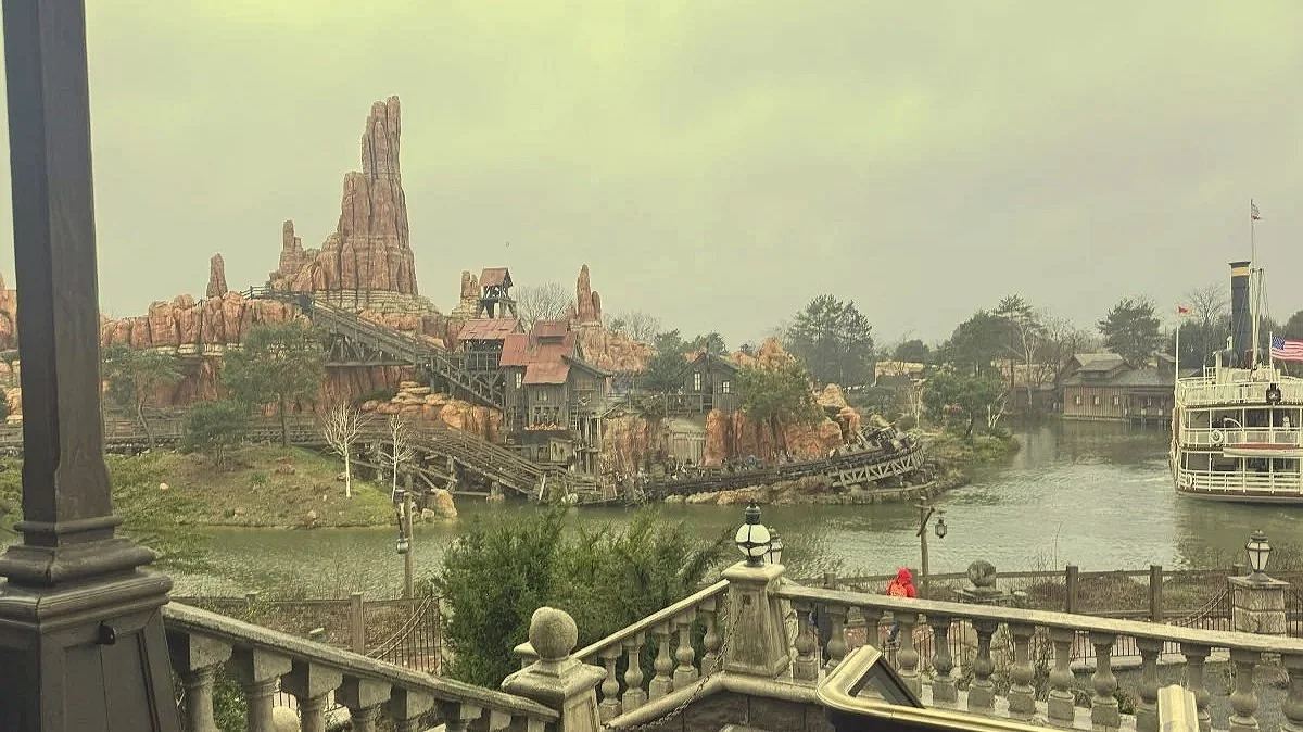 a photo of big thunder mountain and the boat in frontierland in disneyland paris. You can see people riding the roller coaster.