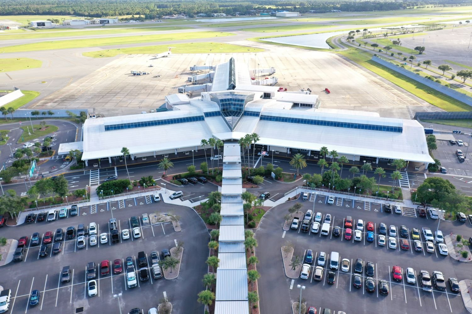 A drone view of Daytona Beach Airport. You can see how small it is with maybe ten gates. You can see an outside parking lot for DAB and the terminals and runways behind it.