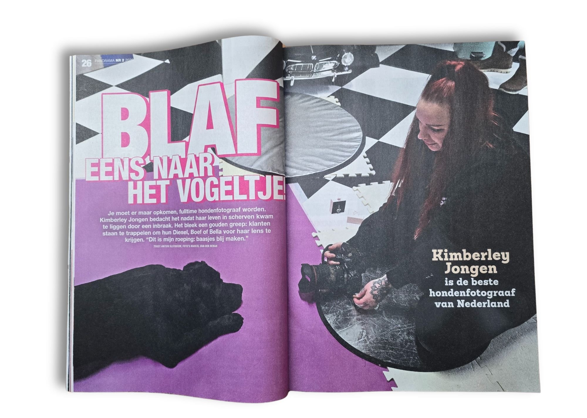 Open magazine met een foto van een vrouw met rood haar die een camera vasthoudt en op een tafel ligt, op een vloer met zachte matten, met grote tekst 'BLAFF' en een koptekst over een hondenfotograaf.