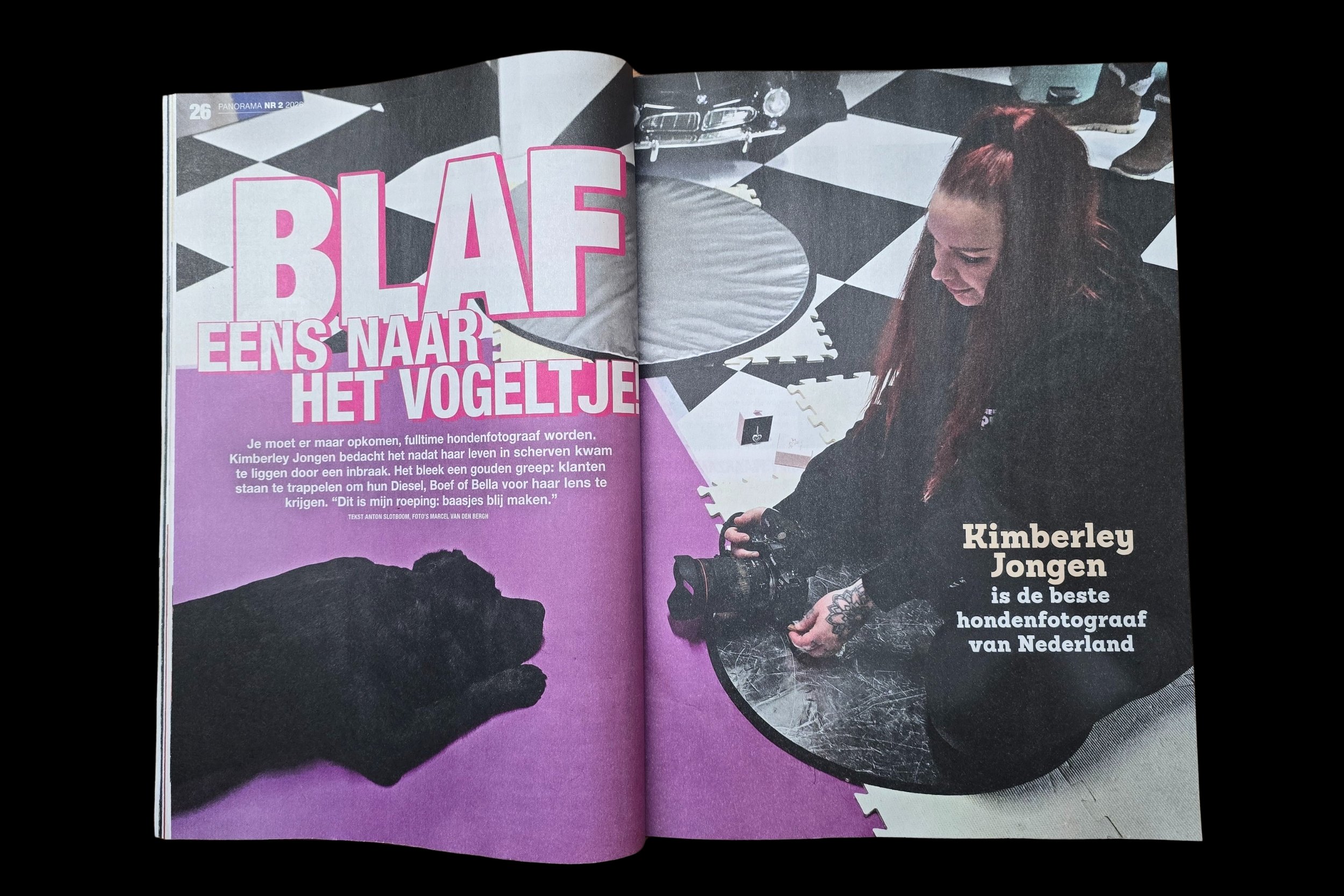 Open magazine met een foto van een vrouw met rood haar die een camera vasthoudt en op een tafel ligt, op een vloer met zachte matten, met grote tekst 'BLAFF' en een koptekst over een hondenfotograaf.