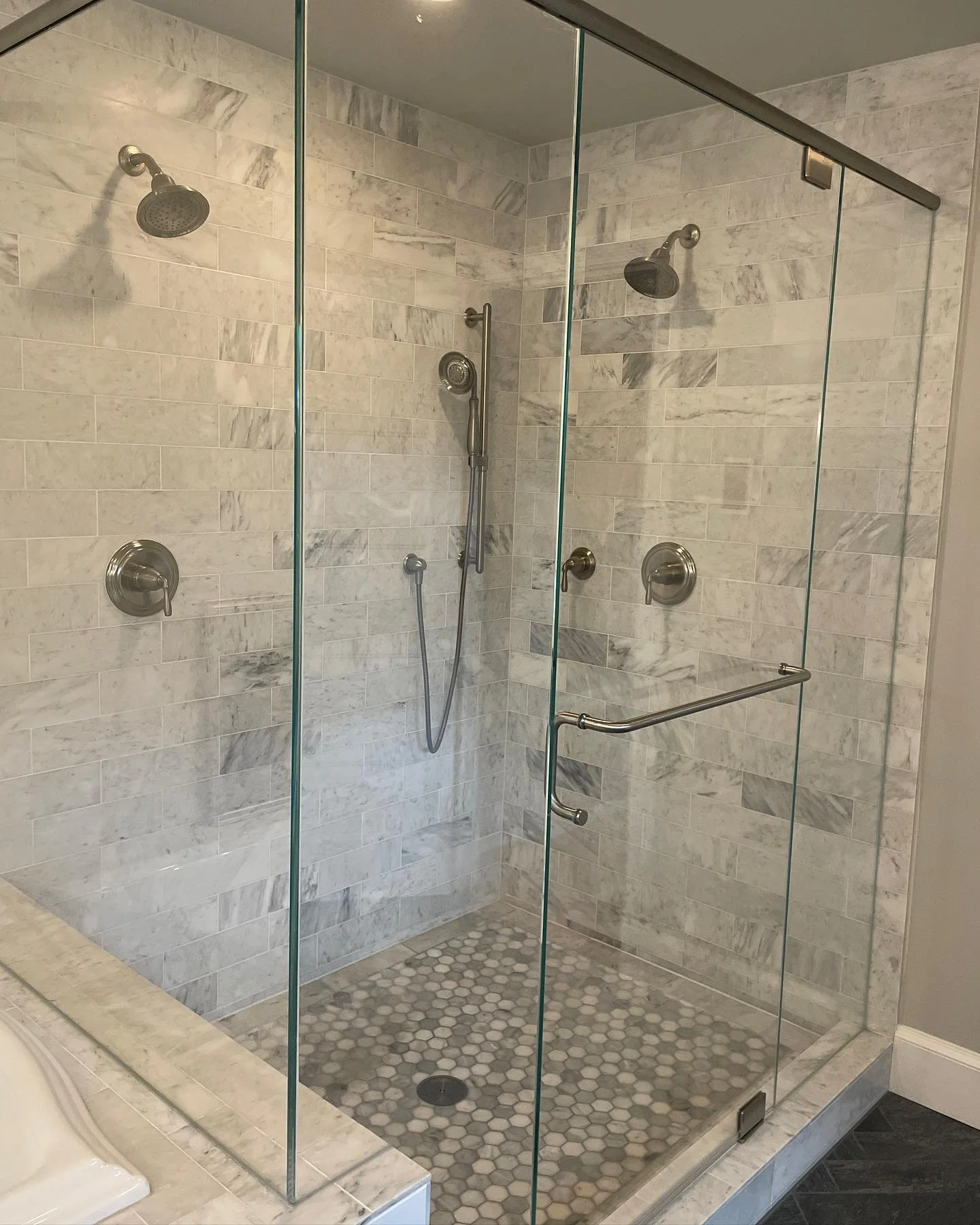 I love marble!! It provides for a timeless design every time.

Marble subway paired with a bordered marble hex tile on the floor. Finished with brushed nickel fixtures.
* My preference - if you can skip the wall niche and have room for a ledge instea