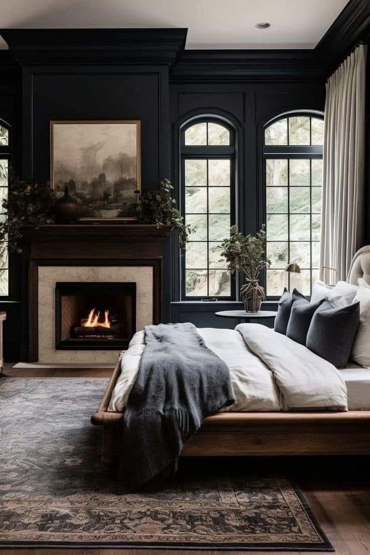 dark and moody master bedroom with fireplace and large arched windows