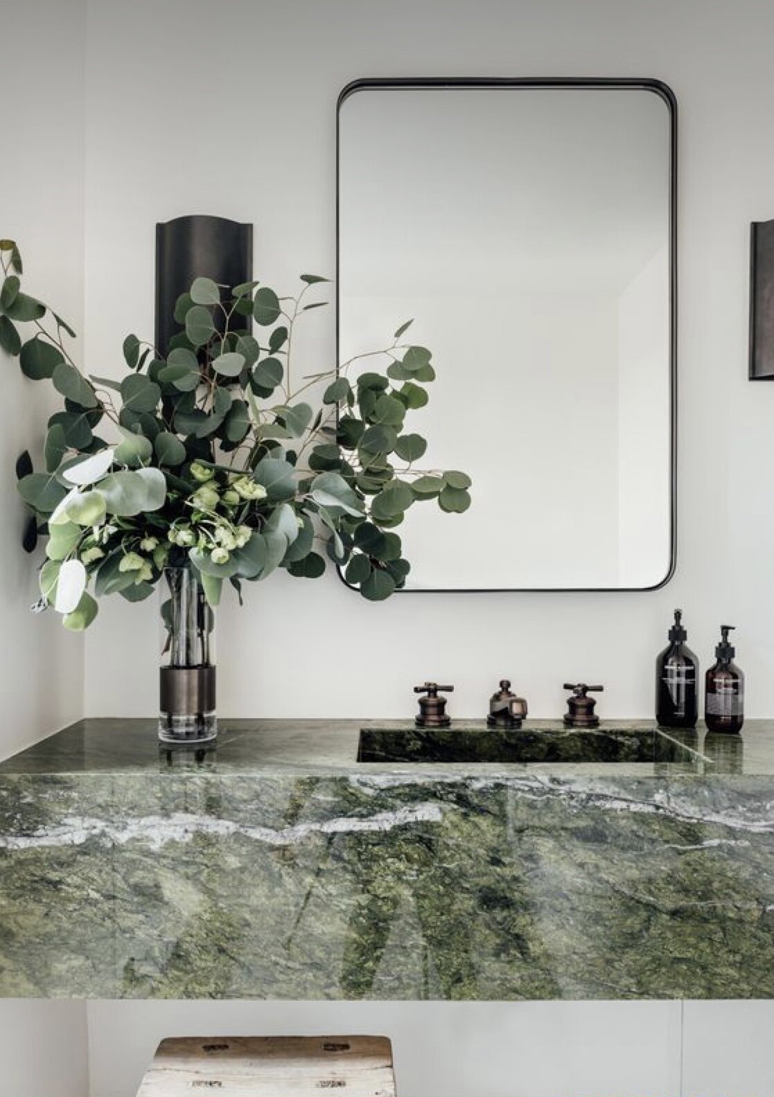 floating green marble basin vanity with eucalyptus bouquet