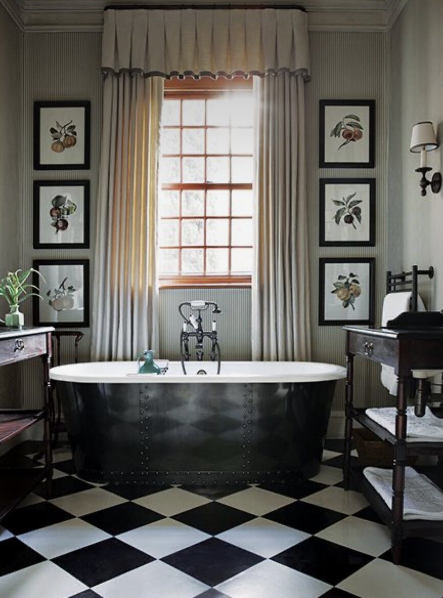 freestanding bathtub with black and white checkered tile flooring in classic bathroom remodel