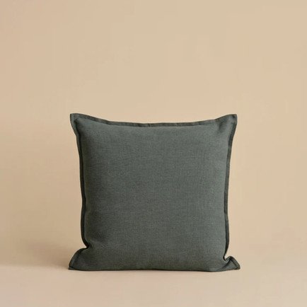 Square charcoal gray Belgian linen throw pillow with tailored piping and a relaxed, natural texture, styled against a warm neutral background.