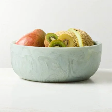 Large pale teal marbled serving bowl filled with fresh mango, kiwi, and cantaloupe, styled against a clean white background.