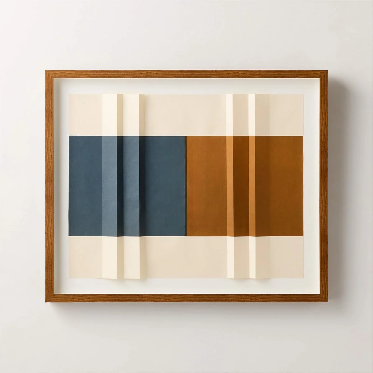 Framed modern geometric wall art with layered folded-paper forms in navy blue, warm ochre, and ivory, displayed in a natural wood frame.