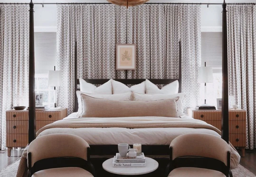 Elegant luxury master bedroom featuring a four-poster bed, soft neutral textiles, symmetrical nightstands, and floor-to-ceiling drapery