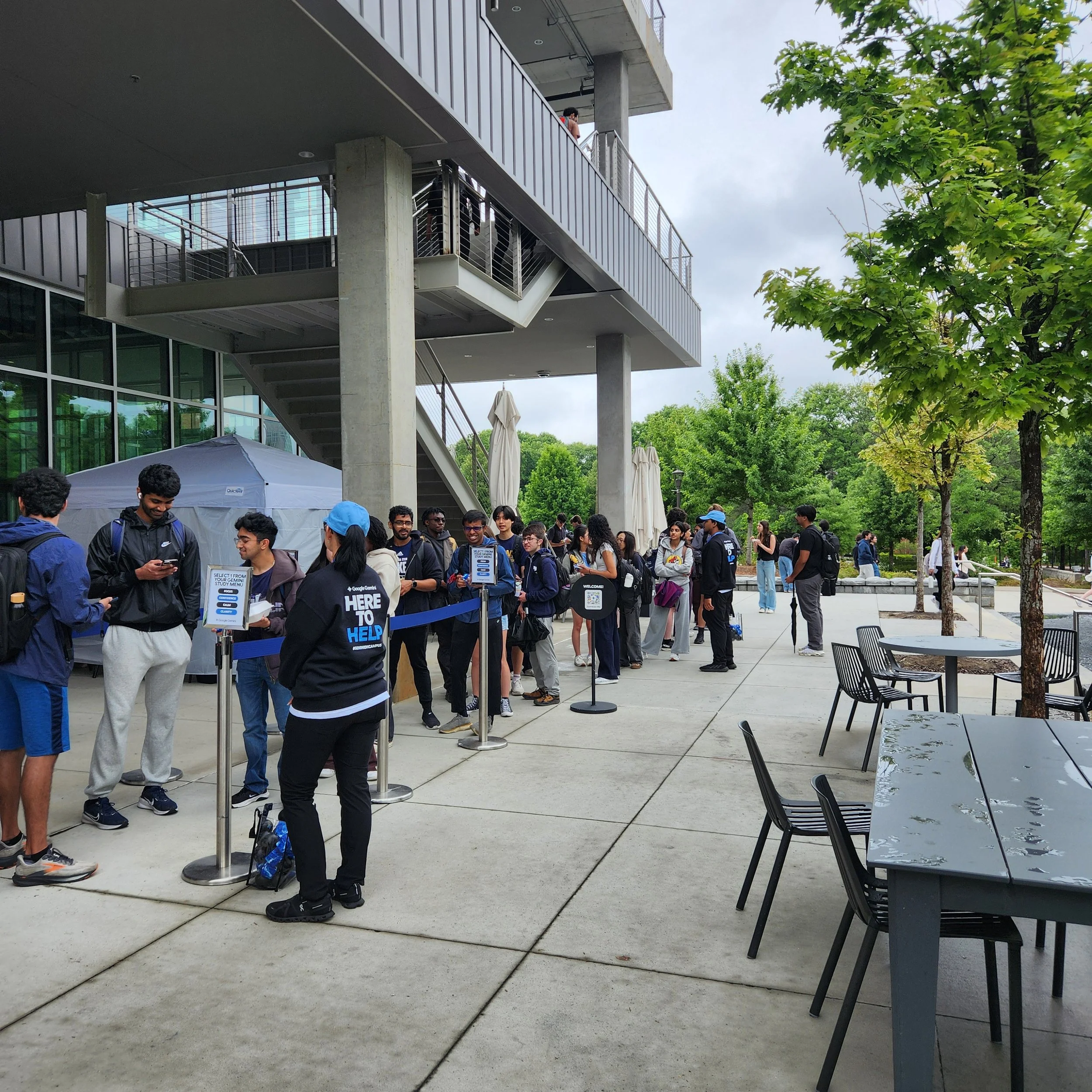 Google Gemini event staff and brand ambassadors assisting a long queue of attendees outside a modern building venue - Encore Nationwide