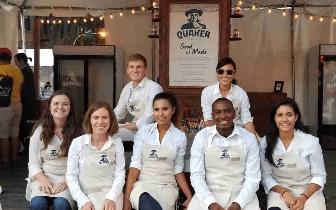 Quaker Oats brand ambassadors and event staff wearing branded aprons at a promotional exhibit booth