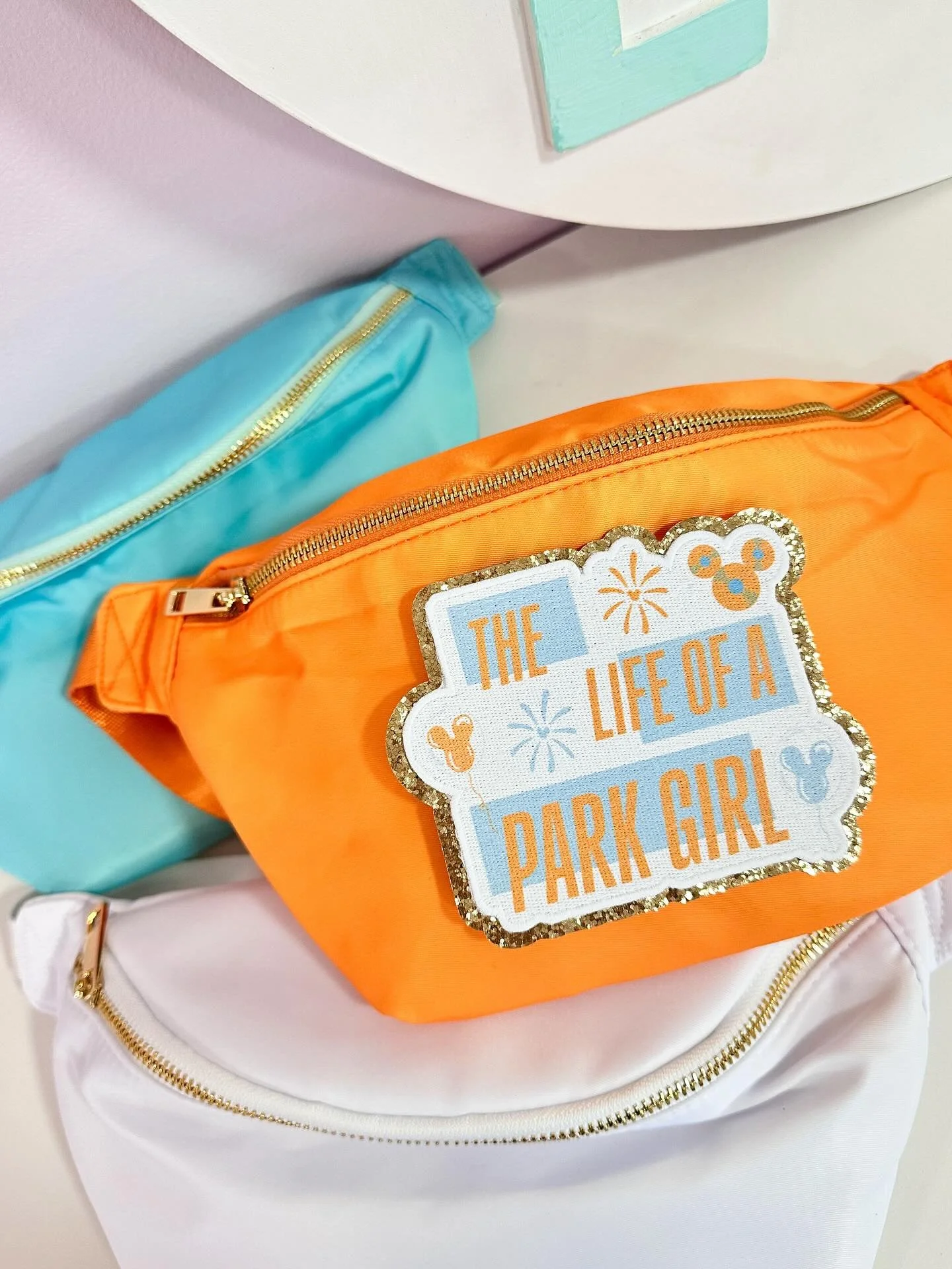 🩵✨🧡 Playing The Life of a Showgirl on repeat since it launched. If you have too this new Life of a park girl collection is for you! New fanny pack, patch, tees and crews available now 🧡✨🩵 Perfect for upcoming Disney park days.