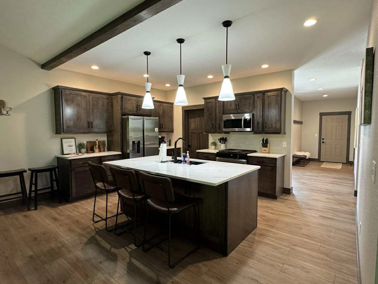 Modern kitchen at Champagne & Ice vacation home in Lead, South Dakota featuring quartz countertops, stainless steel appliances, and island seating.
