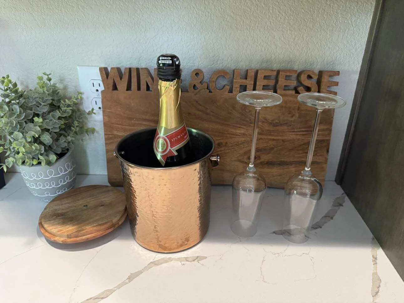 Complimentary champagne setup at Champagne & Ice vacation home in Lead, South Dakota with wine glasses, ice bucket, and rustic decor.
