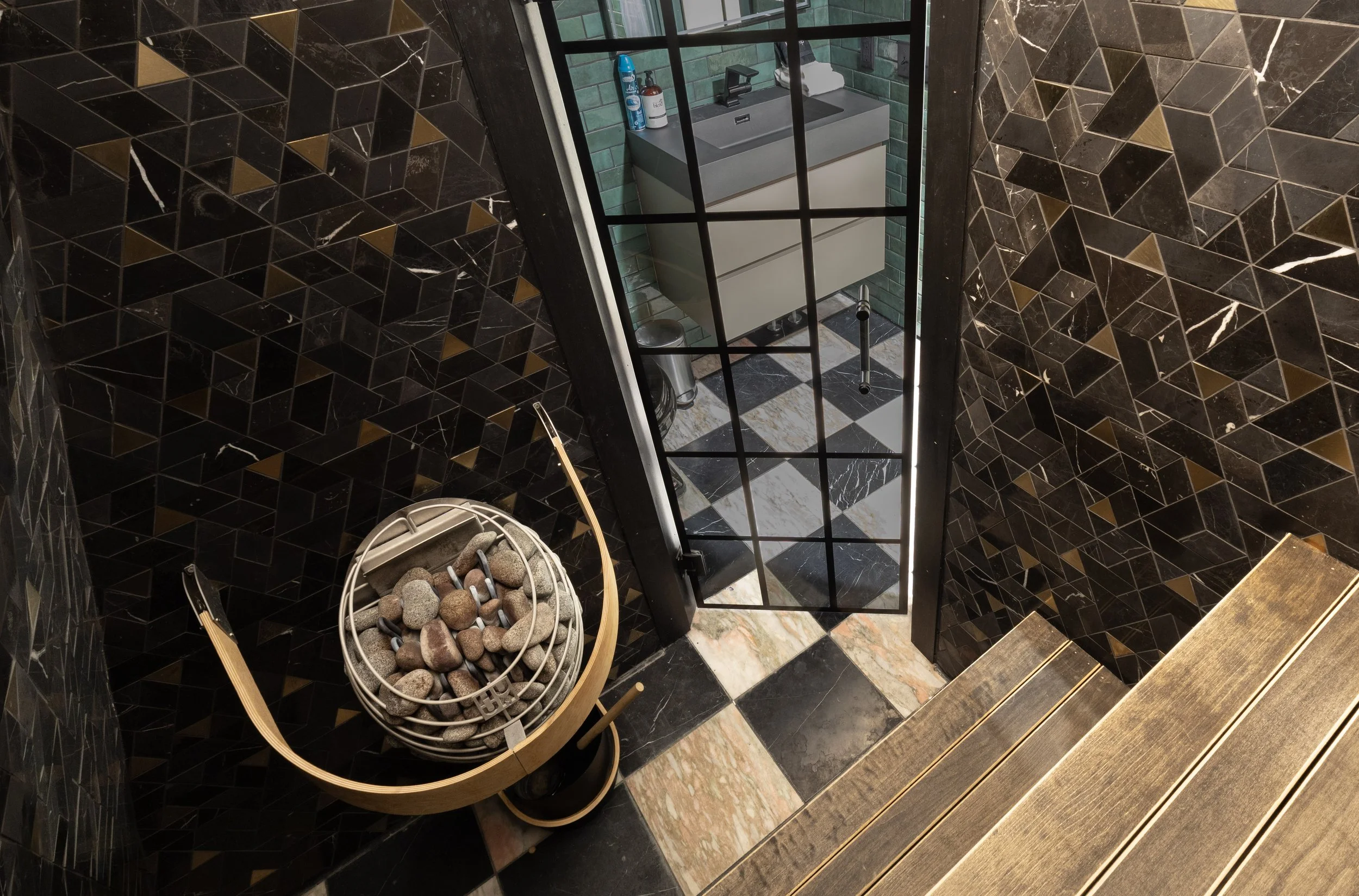 Black Steel Pines Cabin sauna with stone heater and luxury tile design in Lead South Dakota vacation rental