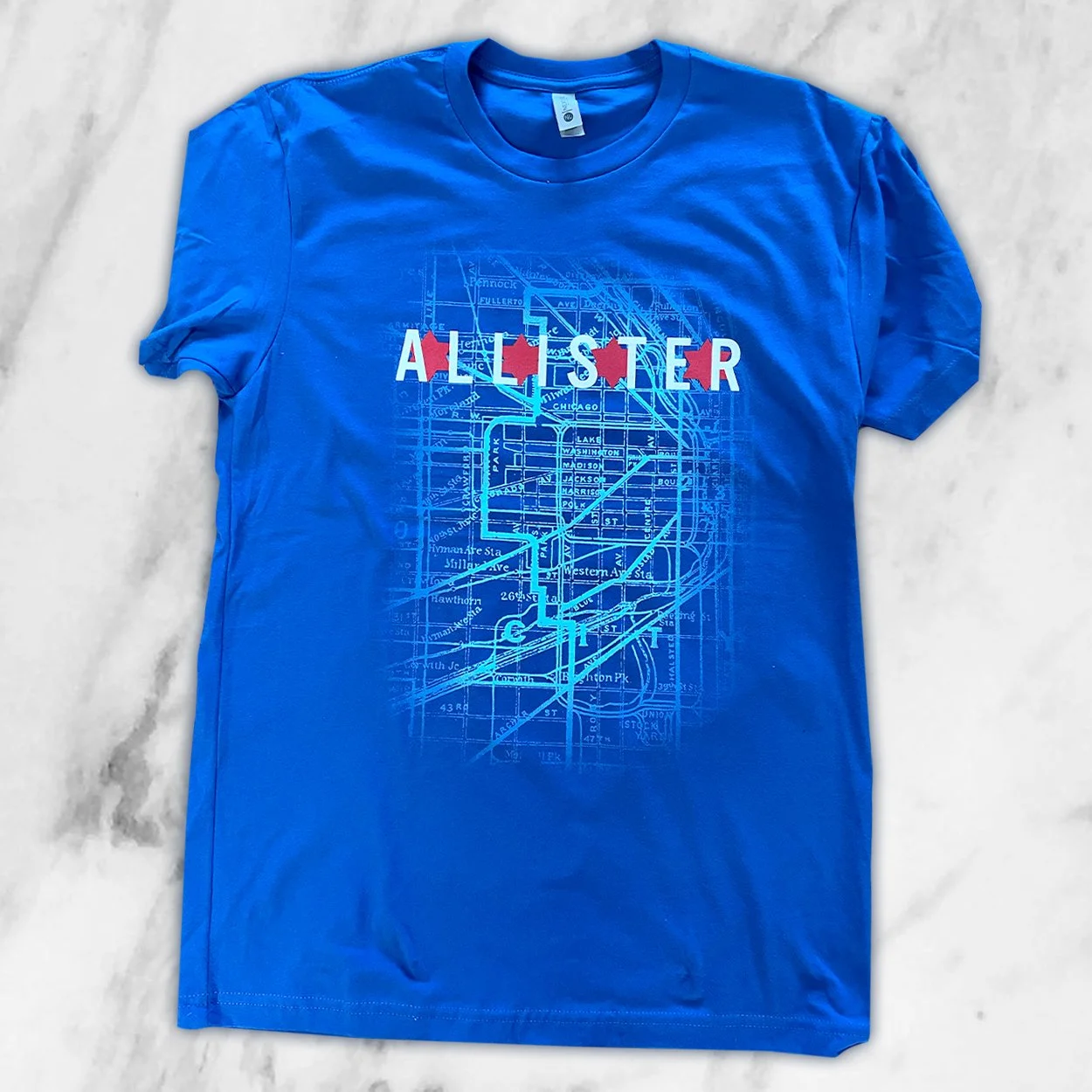 A blue T-shirt with a city map and the word 'Allster' printed across the chest in white and red letters.
