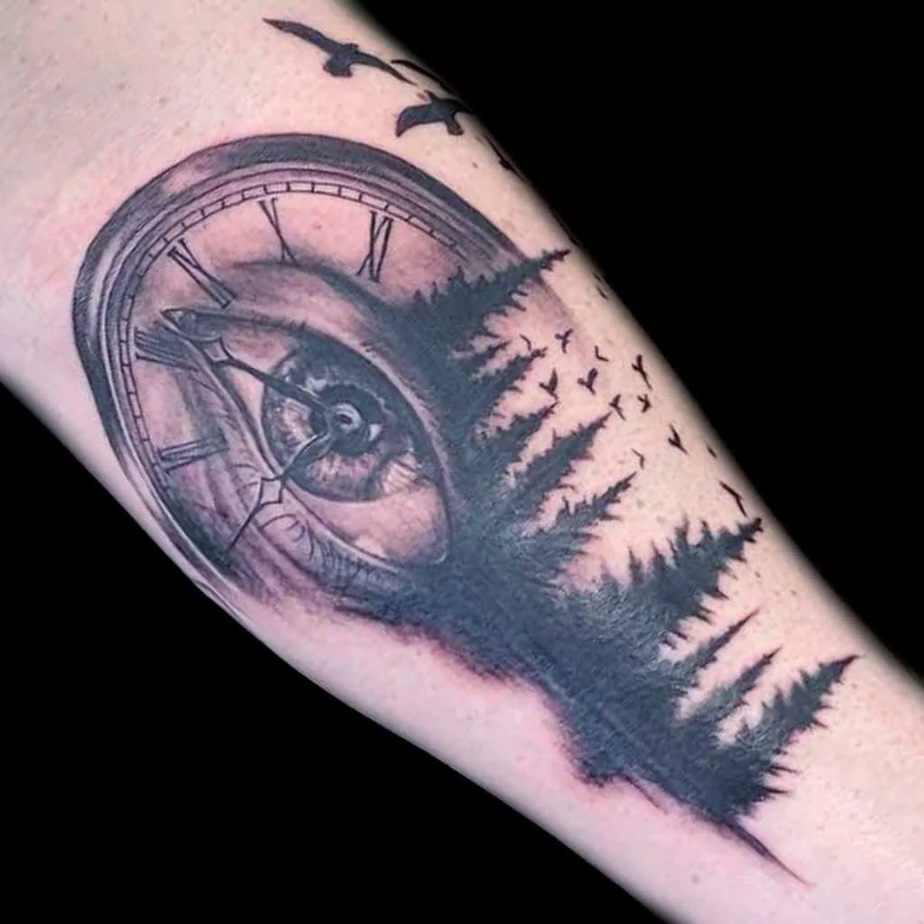 Tattoo of a clock with roman numerals, a mountain landscape, and a forest silhouette with birds flying.