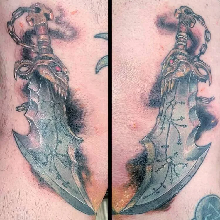 Tattoo of a dagger with a skull handle and a large, detailed blade on skin.