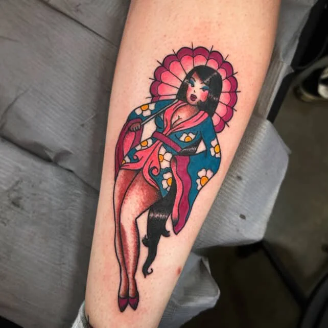 Tattoo of a woman dressed in a colorful kimono with floral patterns, holding an umbrella, wearing a pink parasol behind her, with long black hair and traditional Japanese style.