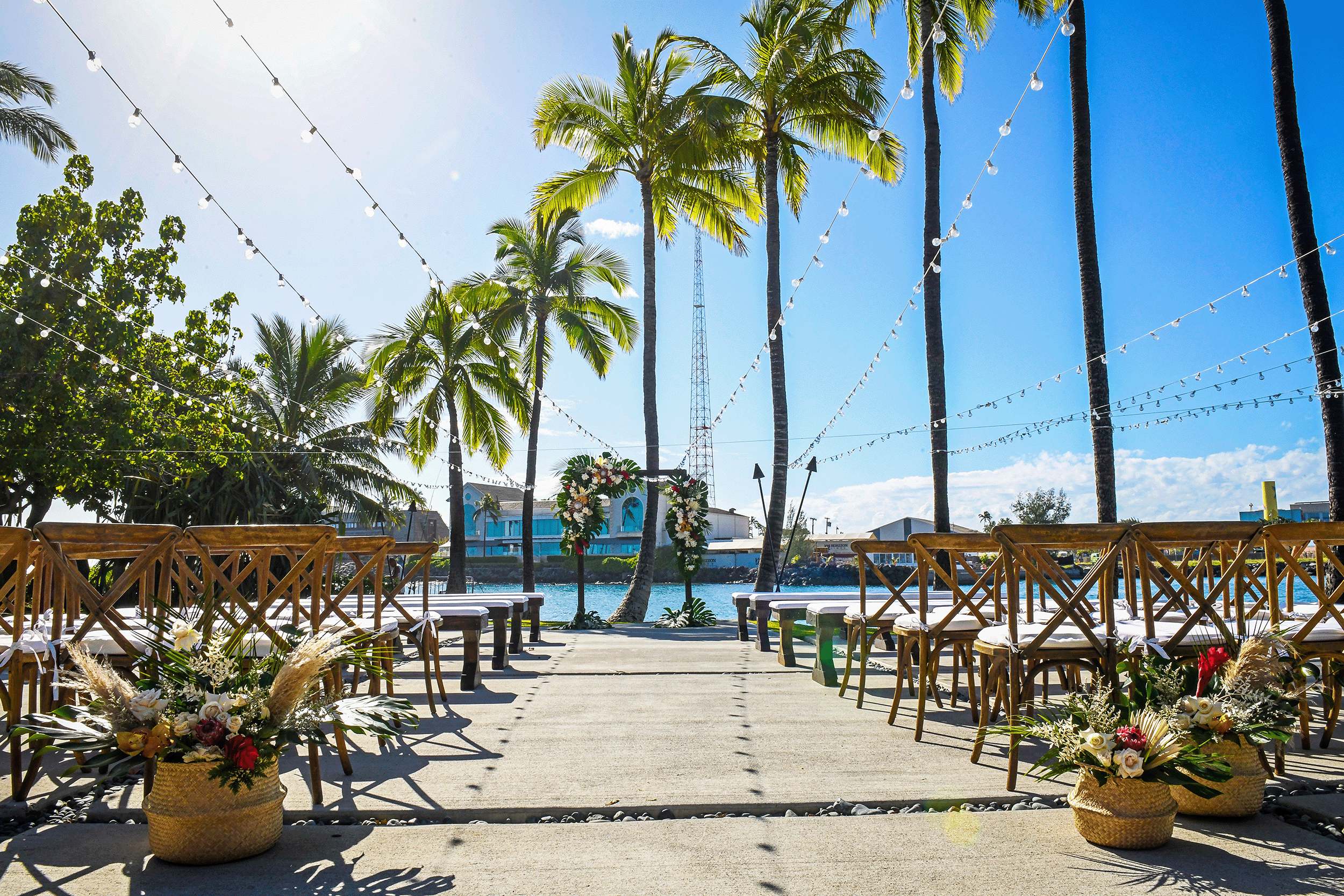 Wedding aisle set outdoors with the picturesque Kewalo Basin as the backdrop.