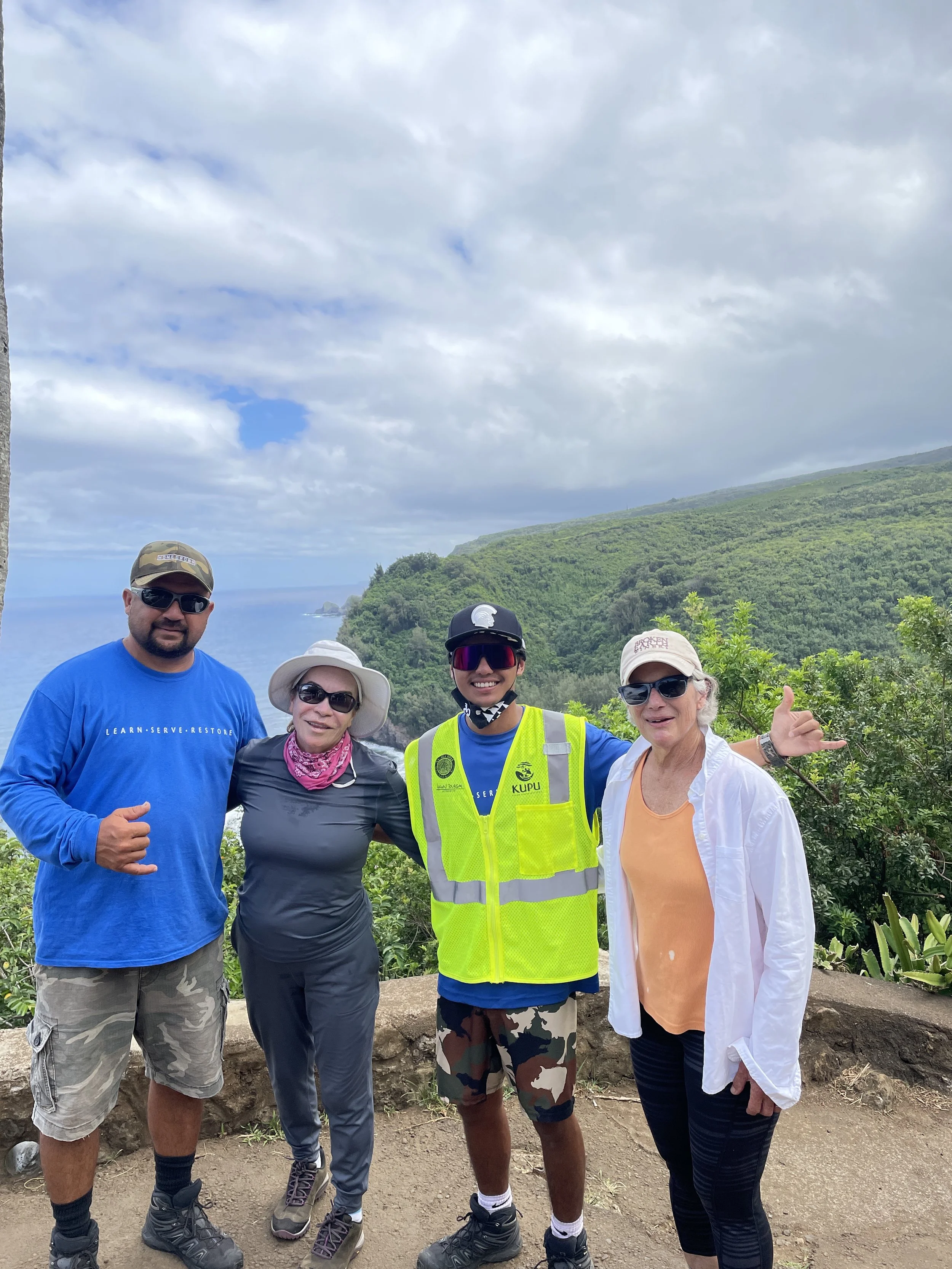 Two Kupu participants and two hikers pose for group photo at start of Polulu Trail.