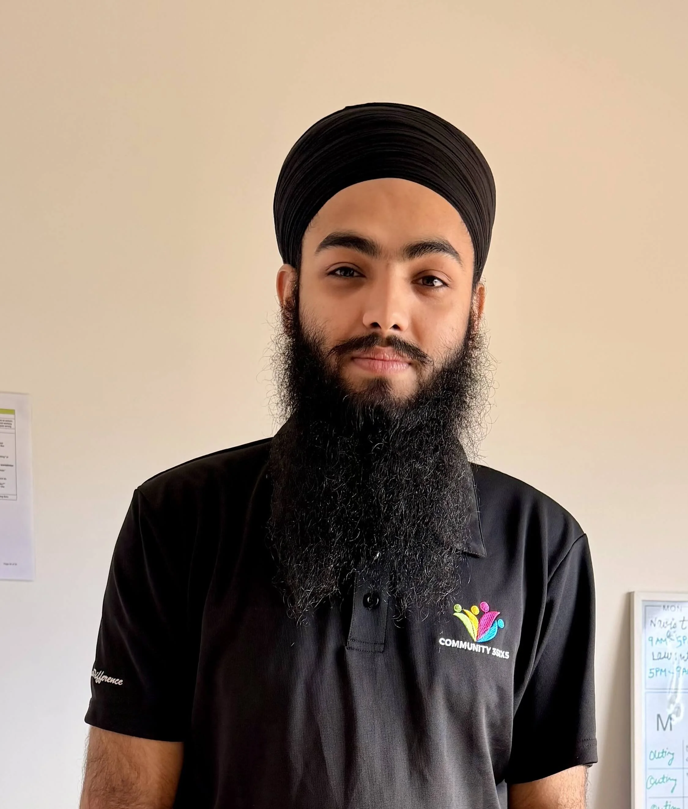 Rajveer Singh, Disability Support Worker at Community 3SIX5, wearing a black company polo shirt.