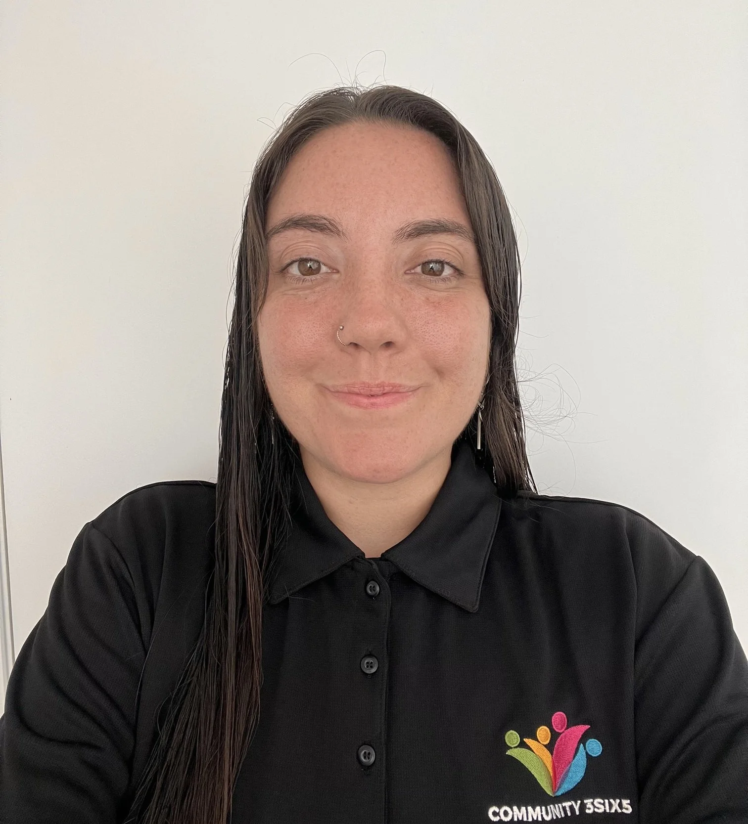 Female staff member Julieta. She has straight brown hair and is wearing a black uniform polo shirt. She is smiling.