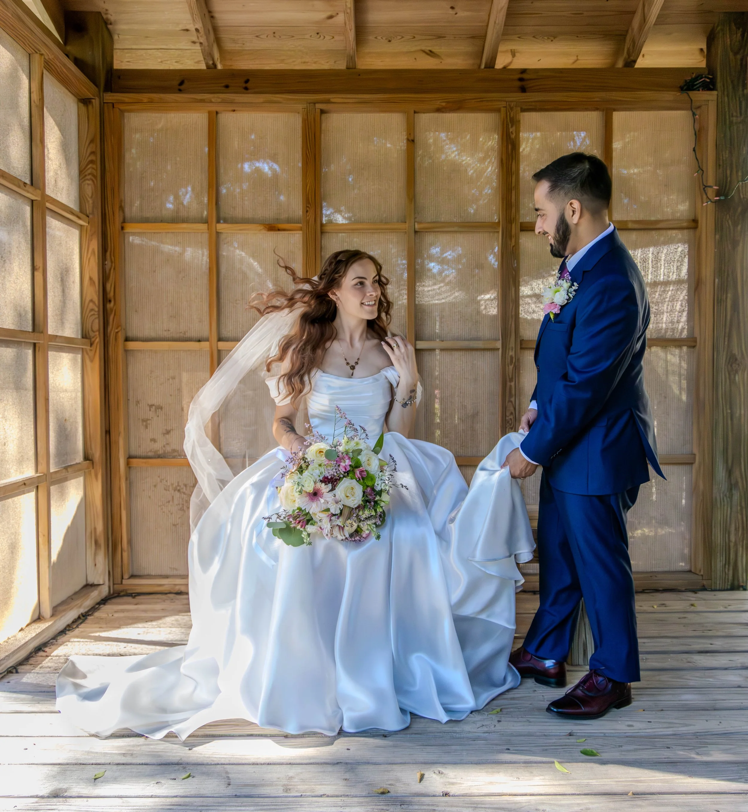 Bride and groom sharing a candid moment during their outdoor wedding ceremony. 