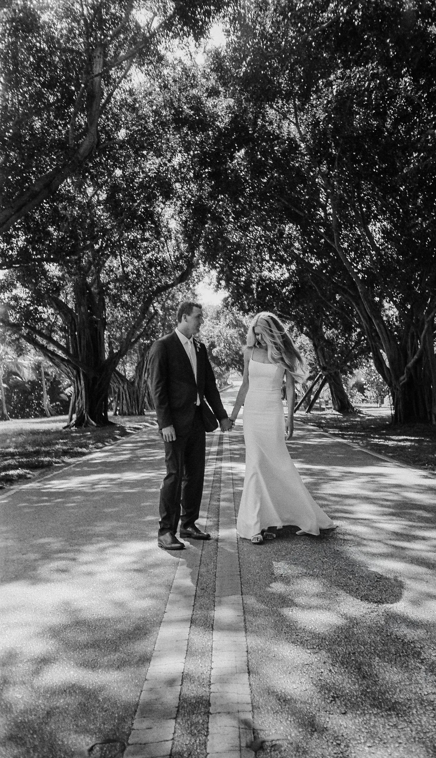 Romantic black-and-white film shot wedding portrait beneath the trees. 