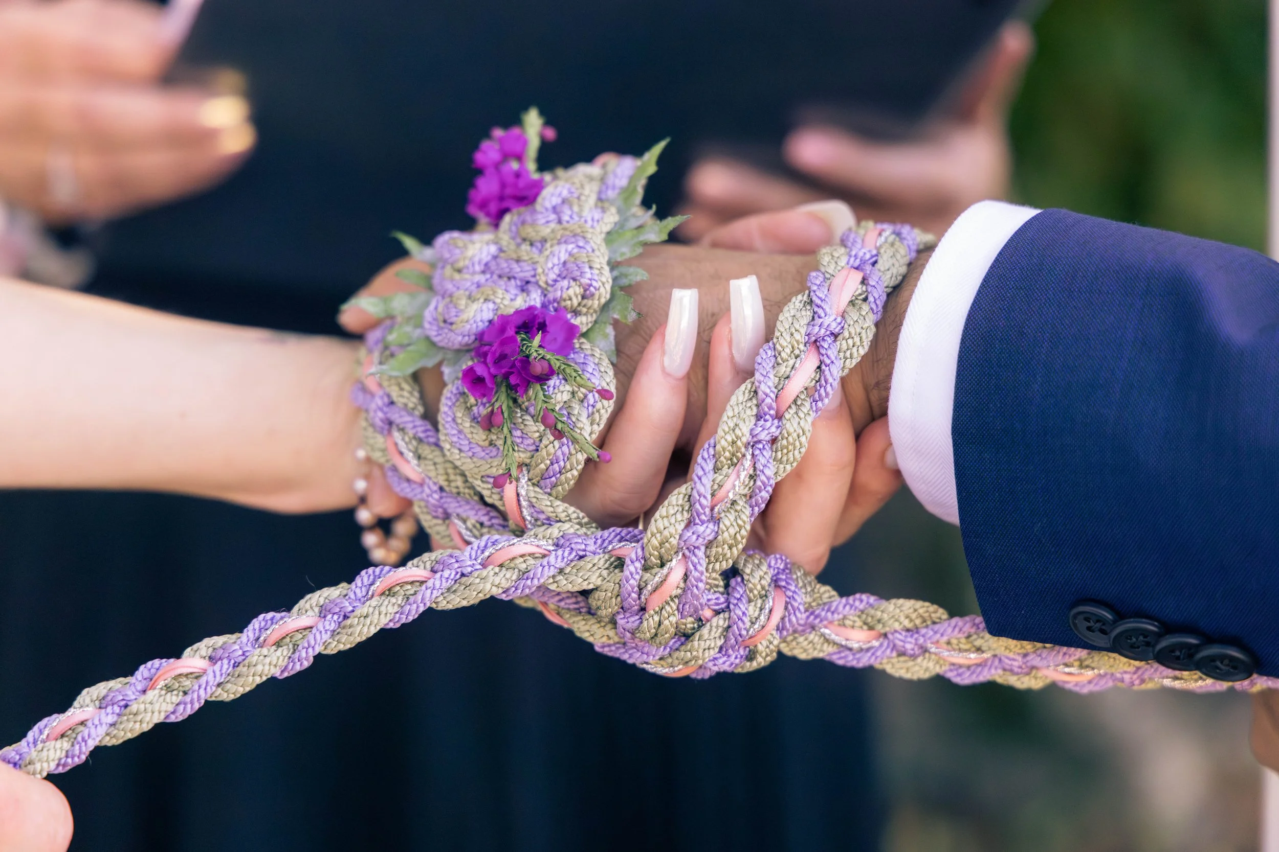 Candid wedding detail photo of a couple holding hands during their ceremony. 