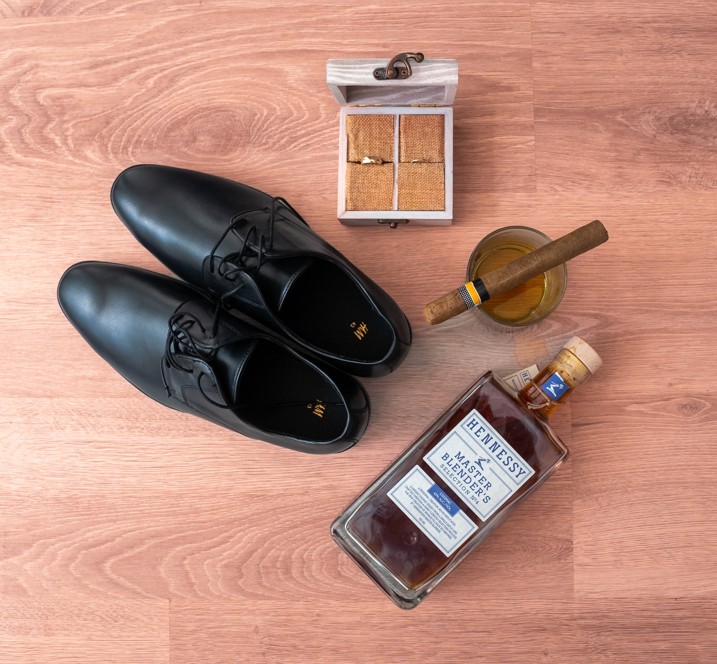 A groom’s signature style — leather shoes, a celebratory cigar, the ring, and a bottle of whiskey before the vows