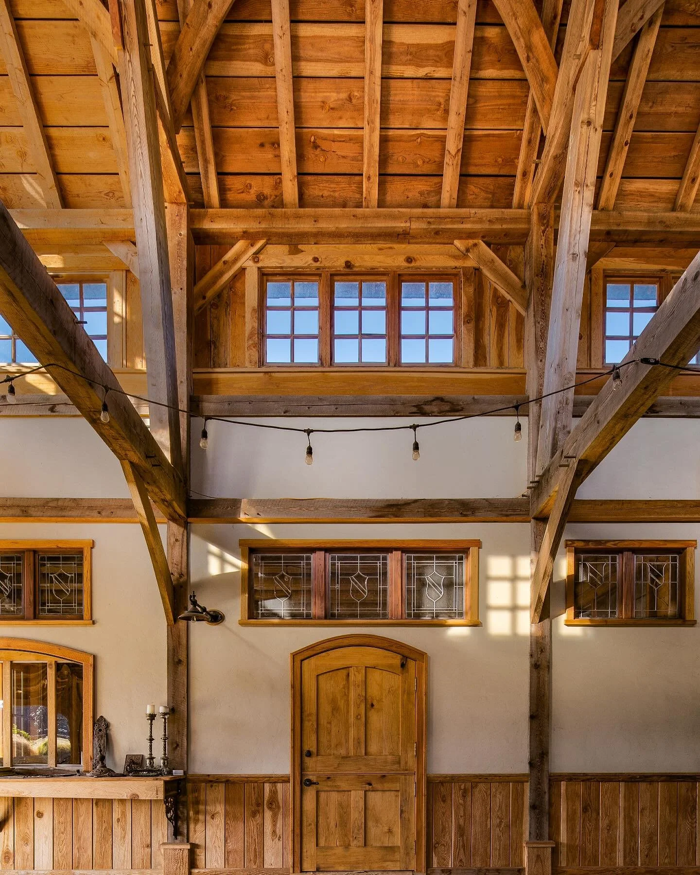 木 Our Aisled Cruck barn, thoughtfully decorated by clients with a developed and eclectic eye&mdash;blending European and American antique windows, doors, hardware, and more.
&zwnj;
Photography @mdvphoto_architecture 
⠀
#sciooregon 
#craftistheremedy
