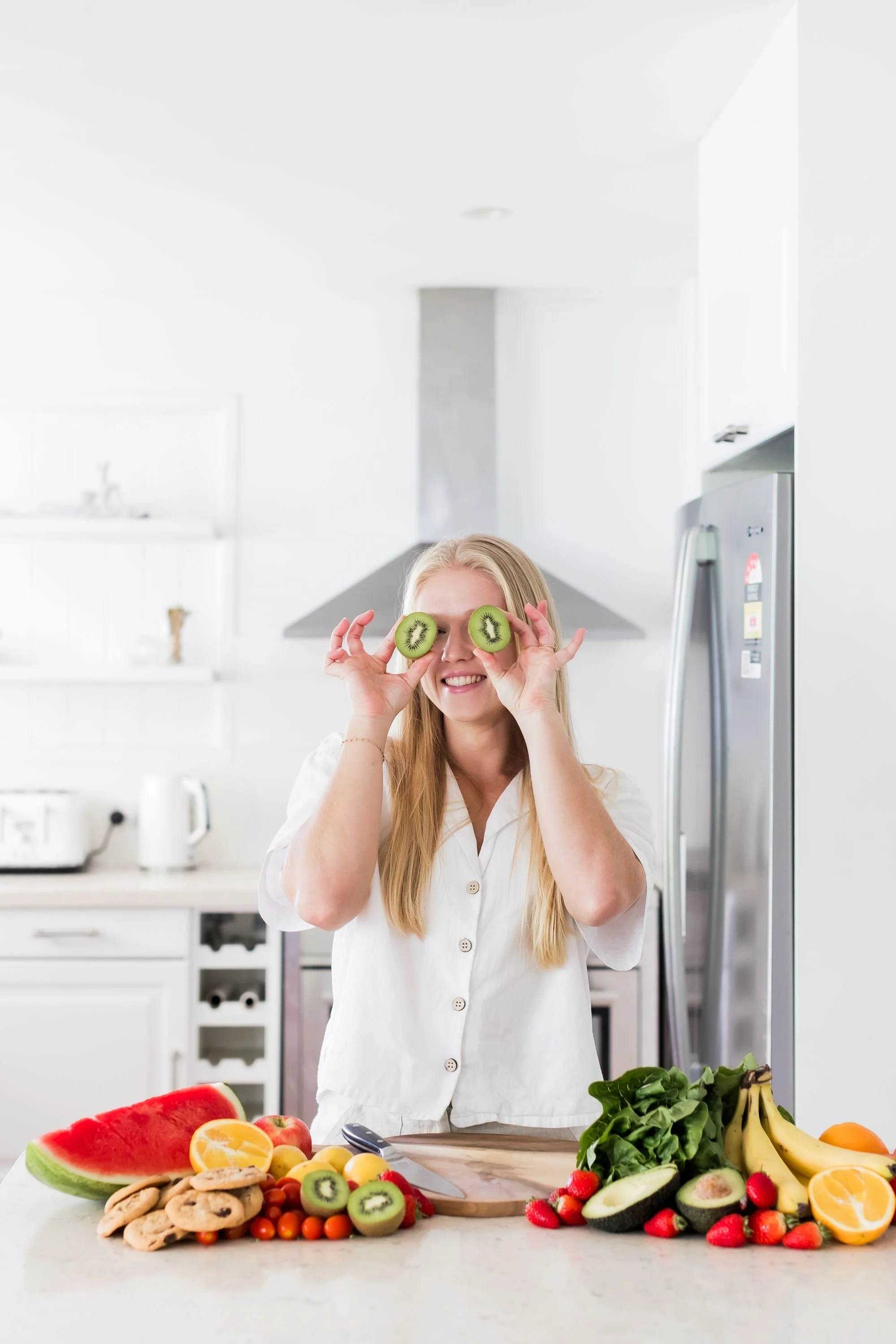 sunshine coast dietitian holding kiwi fruit over eyes