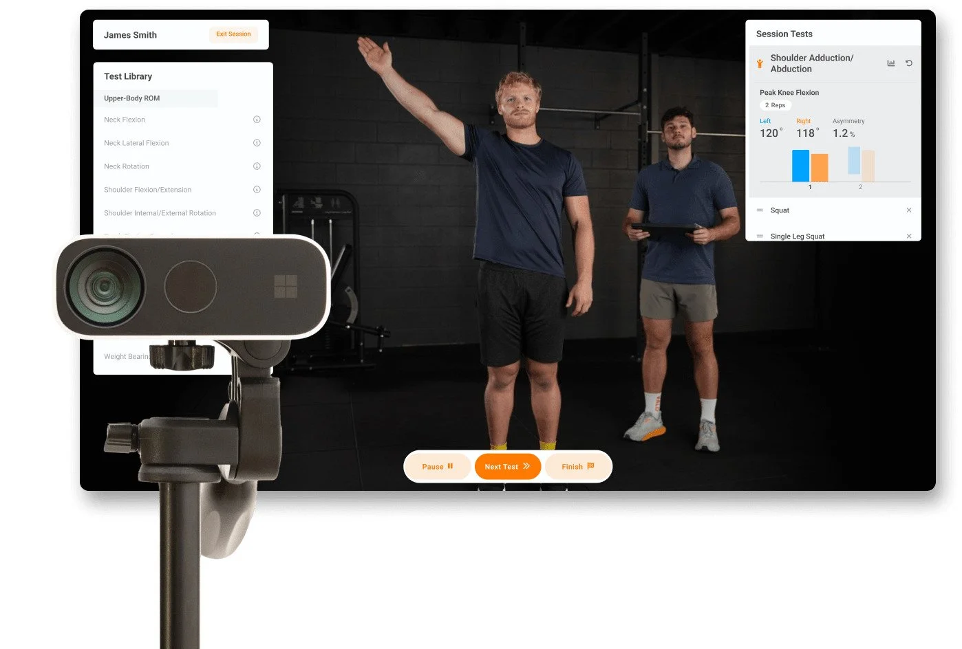 A fitness assessment session with a camera and two men in a gym. One man is performing a shoulder abduction test, while a trainer or researcher observes and notes results on a tablet. The screen shows data charts and test options.